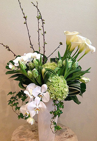 Tall style arrangement of white and green blooms such as Orchids and Calla Lilies