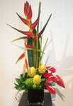 tall one sided arrangement of seasonal tropical flowers