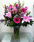 Different shade of pink flowers delivered in a glass vase